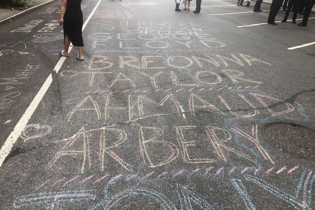 The names of Black people who lost their lives to violence, including killings by police, are drawn on the street.